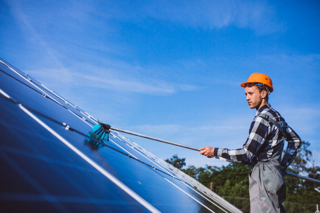 Man worker in the field by the solar panels