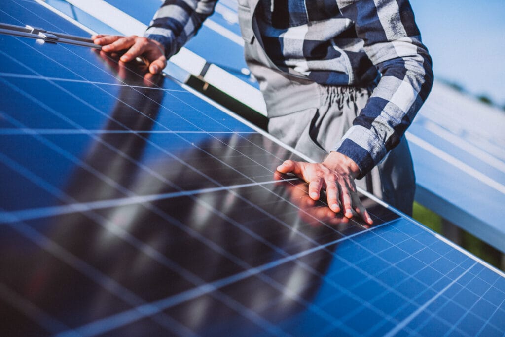 worker checking solar panels