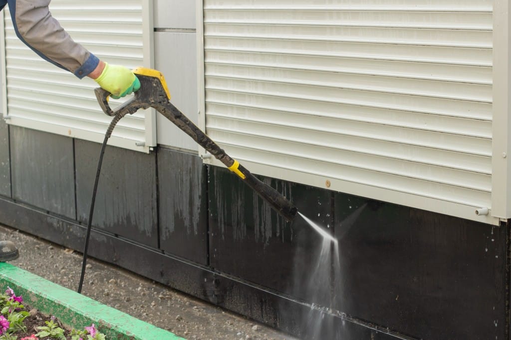 man pressure washing commercial property
